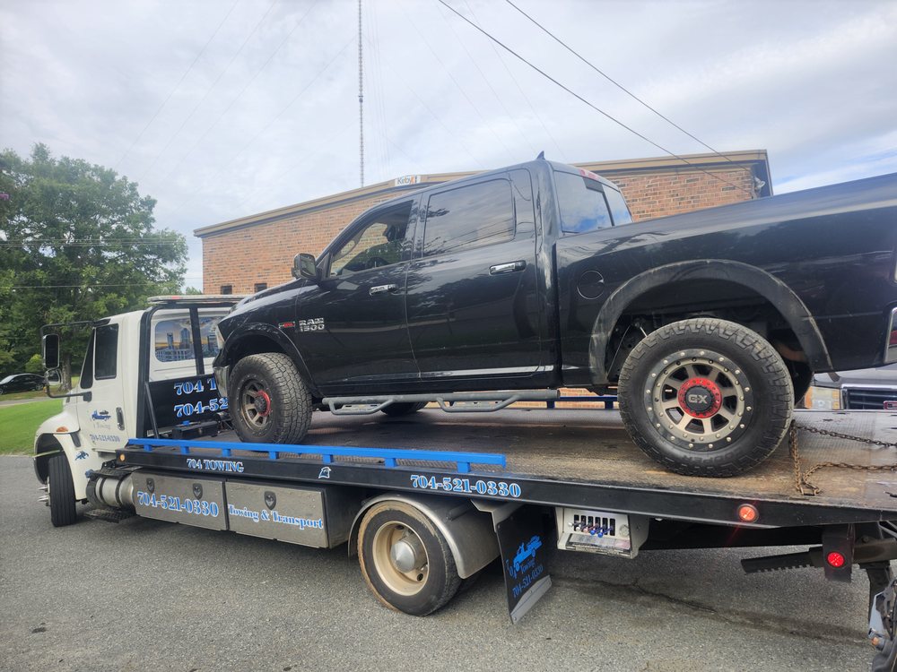 704 Towing flatbed hauling a Ram pickup truck